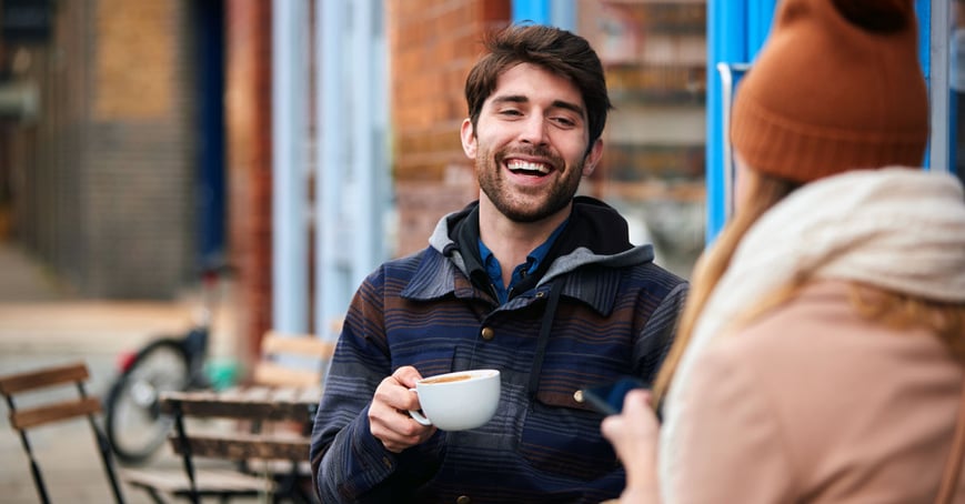 Man holding a coffee cup and smiling