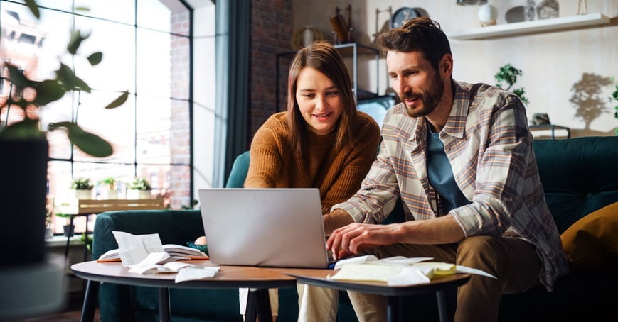 A couple filing taxes at their laptop