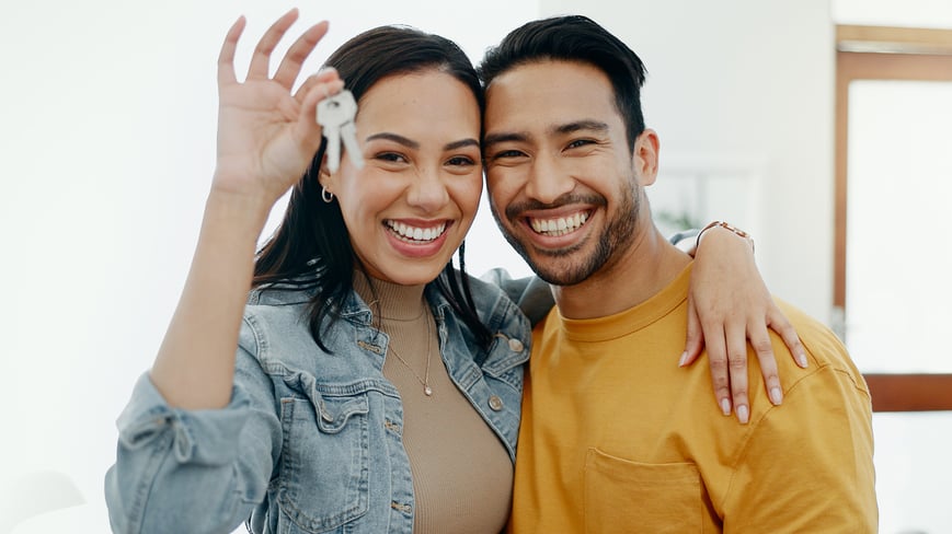 Couple with keys in newly purchased home